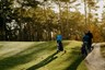 golfers op een bosrijke golfbaan