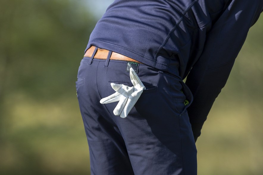 Een golfhandschoen in de kontzak van een golfer. Veel golfers doen hun handschoen af tijdens het putten