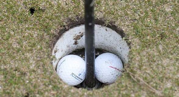 Twee golfballen in de hole