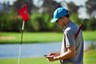 Golfer met mobiele telefoon - score invoeren - handicap