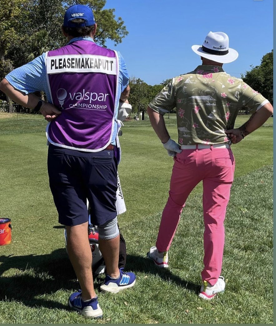 caddie met spreuk op rug