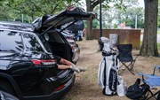 Een slapende golfer in de achterbak van zijn auto op de parkeerplaats van Bethpage Black