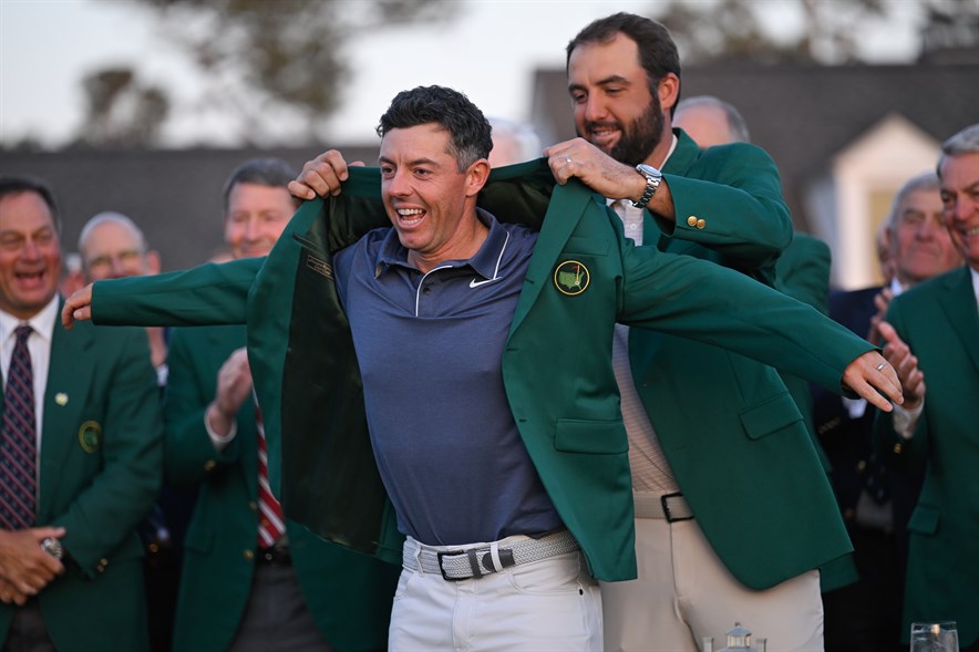 Topgolfer Scottie Scheffler overhandigt het groene jasje aan Rory McIlroy, de winnaar van The Masters in 2025 op Augusta National